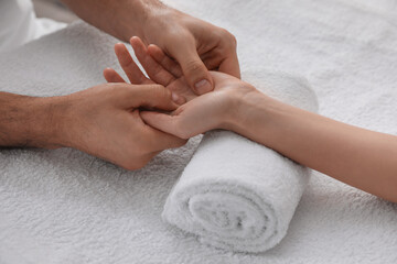 Obraz na płótnie Canvas Woman receiving hand massage on soft towel, closeup