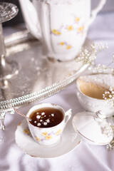 white still life with cheesecake and gypsophila and cup of tea, light and airy