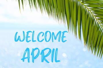 Fototapeta na wymiar Welcome April message written in elegant font on the background with palm leaf and blue sea. Holiday concept and advertising of tour agency. 