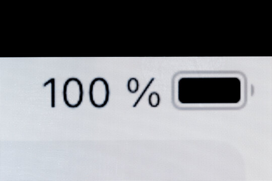 Smartphone full charged pixel battery level indicator - one hundred, 100 percent: close up macro view of gadget display, screen. Energy, technology, power, digital and symbol concept