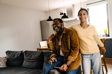 Black girl and her father laughing and using cellphone