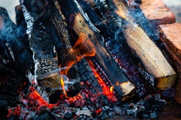 Close-up firewood, hot coals and ash. Lighting barbecue coals.