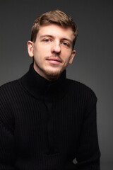 Portrait of young blond european man with short beard and mustache isolated on dark grey