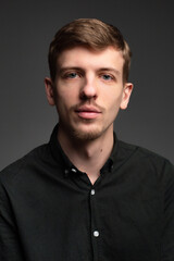 Fototapeta premium Young blond european man with short beard and mustache isolated on dark grey portrait in total black
