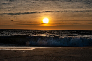 Fototapeta na wymiar Waves breaking onto the shore at sunrise