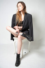 White young european woman sitting on the chair isolated on grey