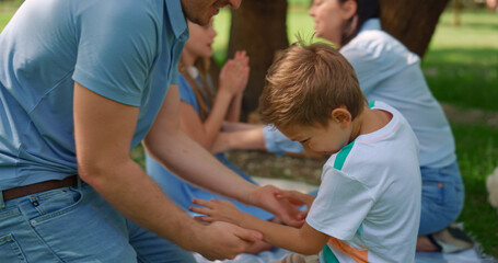 Middle age father tickling son on picnic closeup. Active family play funny games - obrazy, fototapety, plakaty