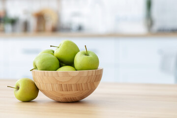 Fresh green apples in a wooden bowl on a wooden table witj copy space. Healthy eating - Powered by Adobe