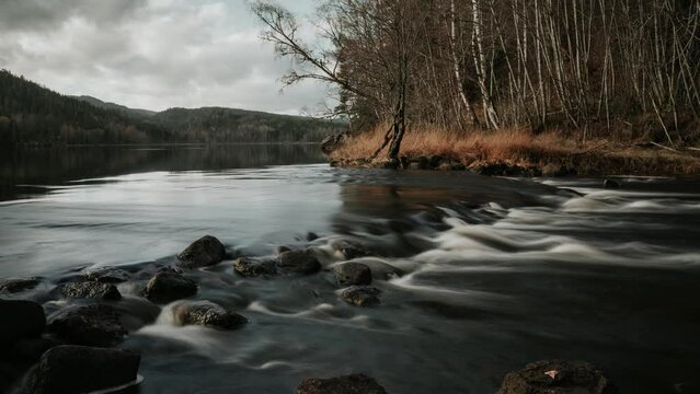 Time lapse video of a forest lake and small waterfall in Autumn in Southern Norway