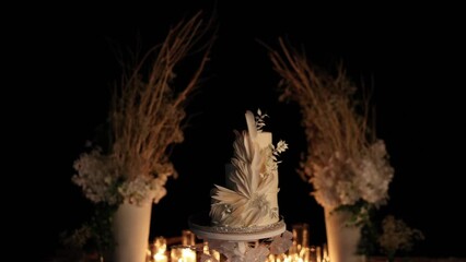 beautiful wedding cake near the wedding arch in the evening