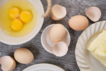 Butter, whole eggs, broken eggs, yolk on a bowl on the table