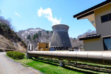 Matsukawa geothermal power plant on dry pine trees moutain on background ,big pipe generator to the...