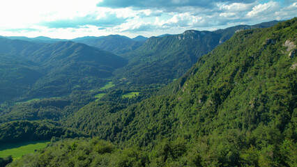 Fototapeta na wymiar AERIAL: Scenic aerial view of the vast valley covered in lush green forests.