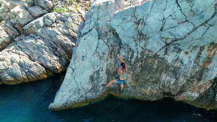 AERIAL: Extreme rock climber deep water solos in the picturesque Adriatic sea.