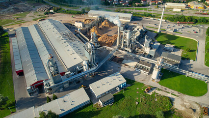 AERIAL: Drone shot of logging factory with a tin-roofed processing facility.