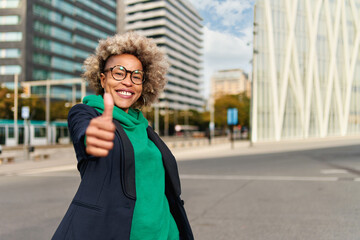 Fototapeta premium Happy professional posing near office building. Young African American business woman. Female business leader concept
