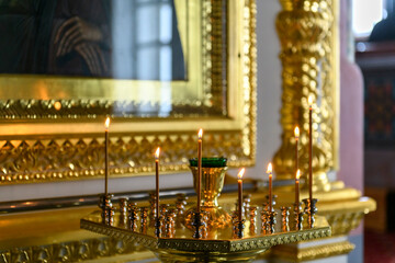 Church candles on the background of icons in Russian orthodox cathedral