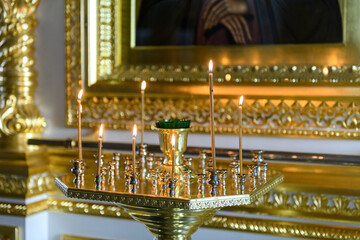 Obraz premium Church candles on the background of icons in Russian orthodox cathedral