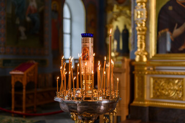 Church candles on the background of icons in Russian orthodox cathedral