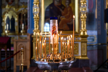 Fototapeta na wymiar Church candles on the background of icons in Russian orthodox cathedral