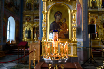 Church candles on the background of icons in Russian orthodox cathedral