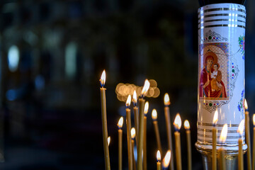 Church candles on the background of icons in Russian orthodox cathedral