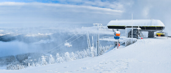 Winter landscape in the Polish mountains of the Sudetes, a ski lift on the Czarna Gora mountain, a thick layer of snow on the slope, a winter afternoon.