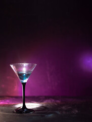 Blue cocktail in a tall glass. Against the background of neon light