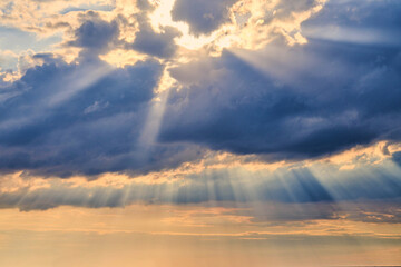 Sun rays and clouds, sunbeams shining through cumulus clouds, stunning scene of natural phenomenon