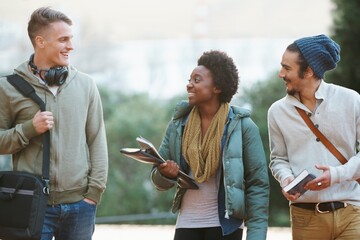 College life. Shot of a college students between classes on the campus grounds.