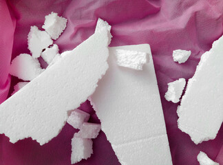 white polystyrene foam on a coarse porous pink fabric. Fractional porous polystyrene foam. bearing...