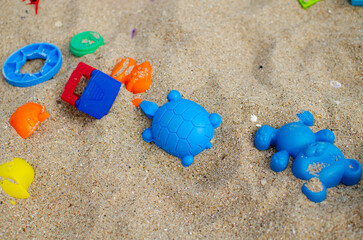 Fototapeta na wymiar Children's sandbox. Plastic molds for sand. Plastic children's toys. Animal figurines.