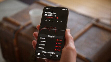 Hand holding Phone with Trading App Mockup watching Crypto Currency Investment falling in Euros