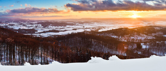 Winter landscape in the Polish mountains of the Sudetes, a panorama from the Klodzka Gora observation tower over the mountain valley at sunset.