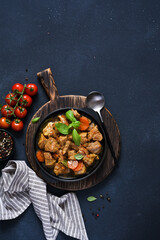 Stew with spices, tomatoes and carrots on a concrete cheno background.