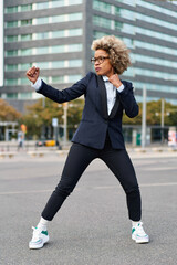Tough competitive business concept. African American woman in a fighting pose with raised fists.