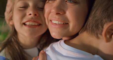 Smiling mother enjoy cuddling with children close up. Happy family moments.