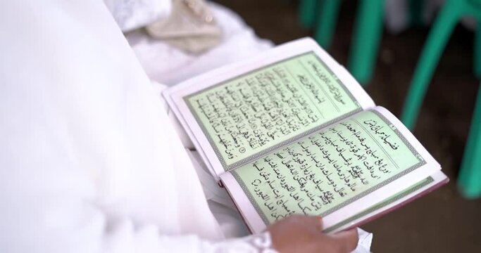 Woman reading Koran with focus on famous verse.