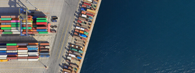 Aerial drone ultra wide top down photo of commercial container terminal with cranes loading...