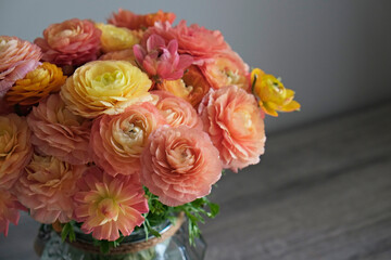 Close up shot of beautiful orange and red ranunculus bouquet. Visible petal structure. Detailed bright patterns of flower buds. Top view, background, copy space for text.
