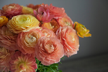 Close up shot of beautiful orange and red ranunculus bouquet. Visible petal structure. Detailed bright patterns of flower buds. Top view, background, copy space for text.