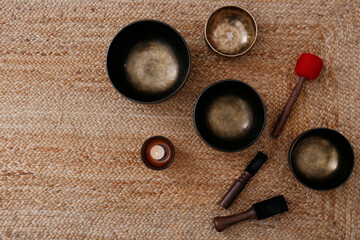 Tibetan singing bowls of different size and other equipment for sound healing session. Attributes...