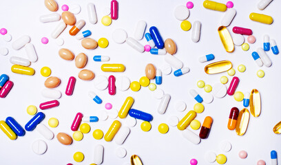 Variety of drugs in capsules and tablets in different colors on a white background. Medical concept. Pharmaceuticals