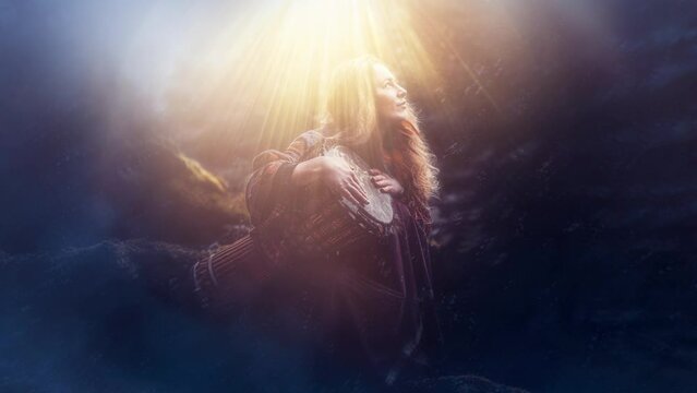 beautiful shamanic girl playing on drum in the nature.
