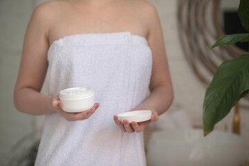 woman applying cream on face