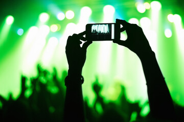 A person filming their favorite band with a camera phone. This concert was created for the sole...