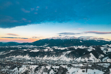 Sunset aerial with Moeciu and Bran in Brașov County, Transylvania, Romania. Bucegi Mountains on the background in the historical sub-region of Tara Barsei, Burzenland in search for wilderness, nature