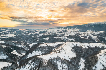 Sunset winter landscape from Transylvania Romania, Pestera Village in search for wilderness, nature, and countryside, Piatra Craiului mountains on background, people reconnect with nature