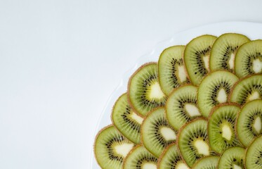 kiwi lies on a white plate on a white background