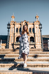 Obraz premium Cheerful smiling pretty woman in summer dress sightseeing in Europe